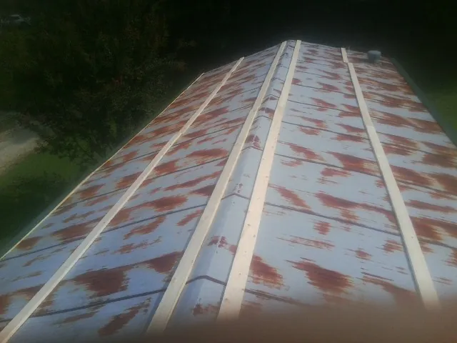 Rusted metal roof panels with new wood purlins before replacement — Storm Damage Roof Repair in Matteson by Roofing Brothers