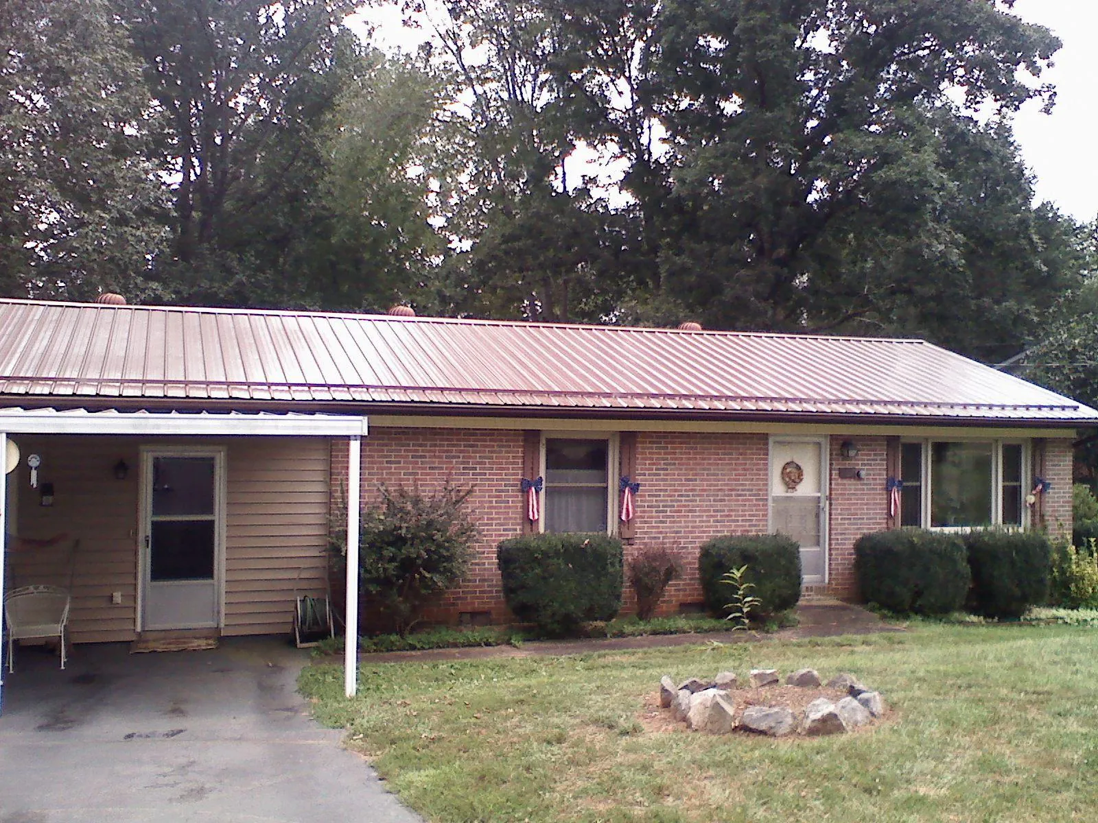 Bronze metal roof and carport on a brick ranch home — Roof Repair work by our crew in Matteson